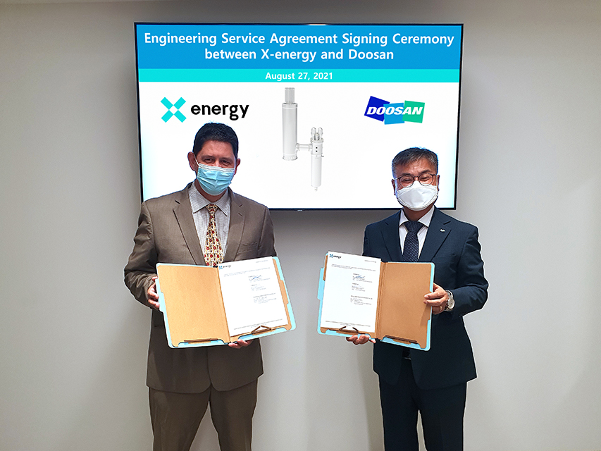 Martin Van Staden, Vice President of X-energy, and Jongdoo Kim, Vice President of Doosan Heavy, sign an agreement at the X-energy headquarters located in Rockville, Maryland.