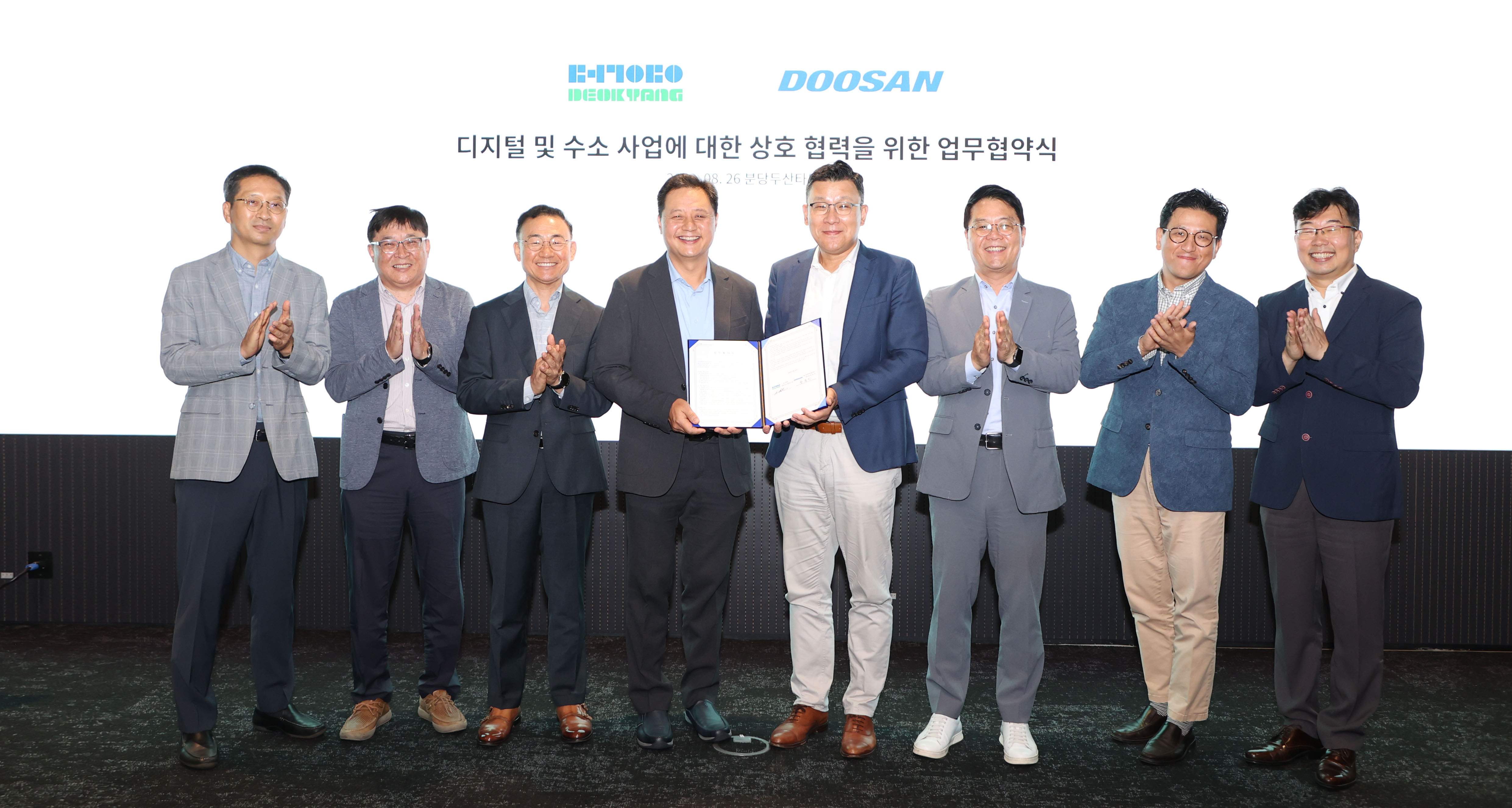 Doosan Enerbility CSO Yongjin Song (fifth from the left) and Deokyang CEO James Kim (fourth from the left) pose for a group photo with related parties at the MoU signing ceremony held at the Bundang Doosan Tower on Aug. 26th.