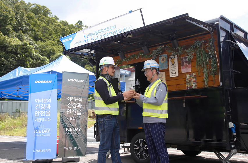 The site director Hyungdo Lee (on the right) hands out coffee to the employees at the Hamyang-Changnyeong Expressway site in Hapcheon County.