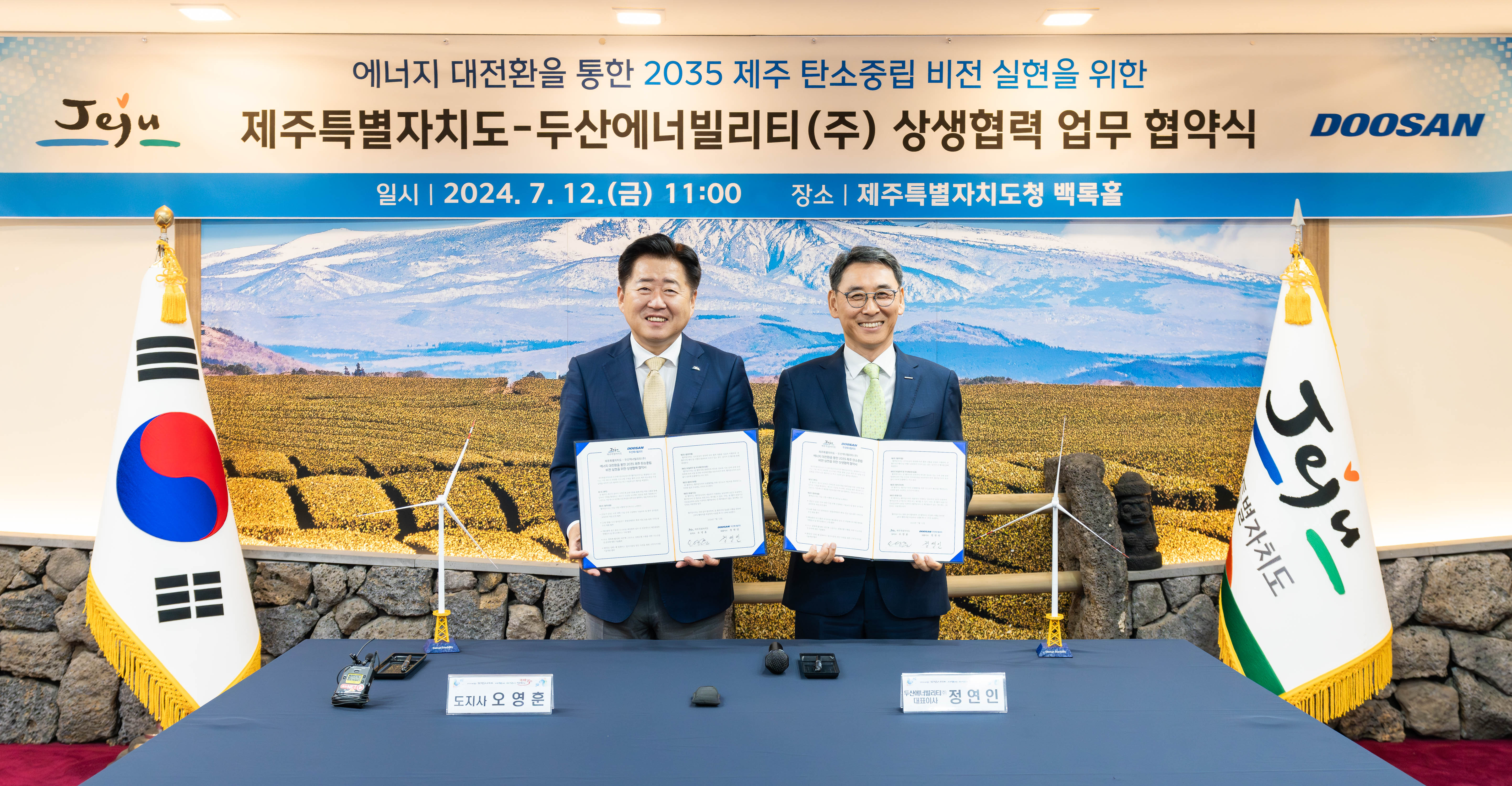 On July 12, Jeju Governor Young-hun Oh (on the leftl) and Doosan Enerbility Vice Chairman Yeonin Jung pose for a photo after signing the “MOU on Cooperation for Achieving Carbon Neutrality by 2035 Via Energy Transition” at the Jeju City Hall’s Baekrok Hall.