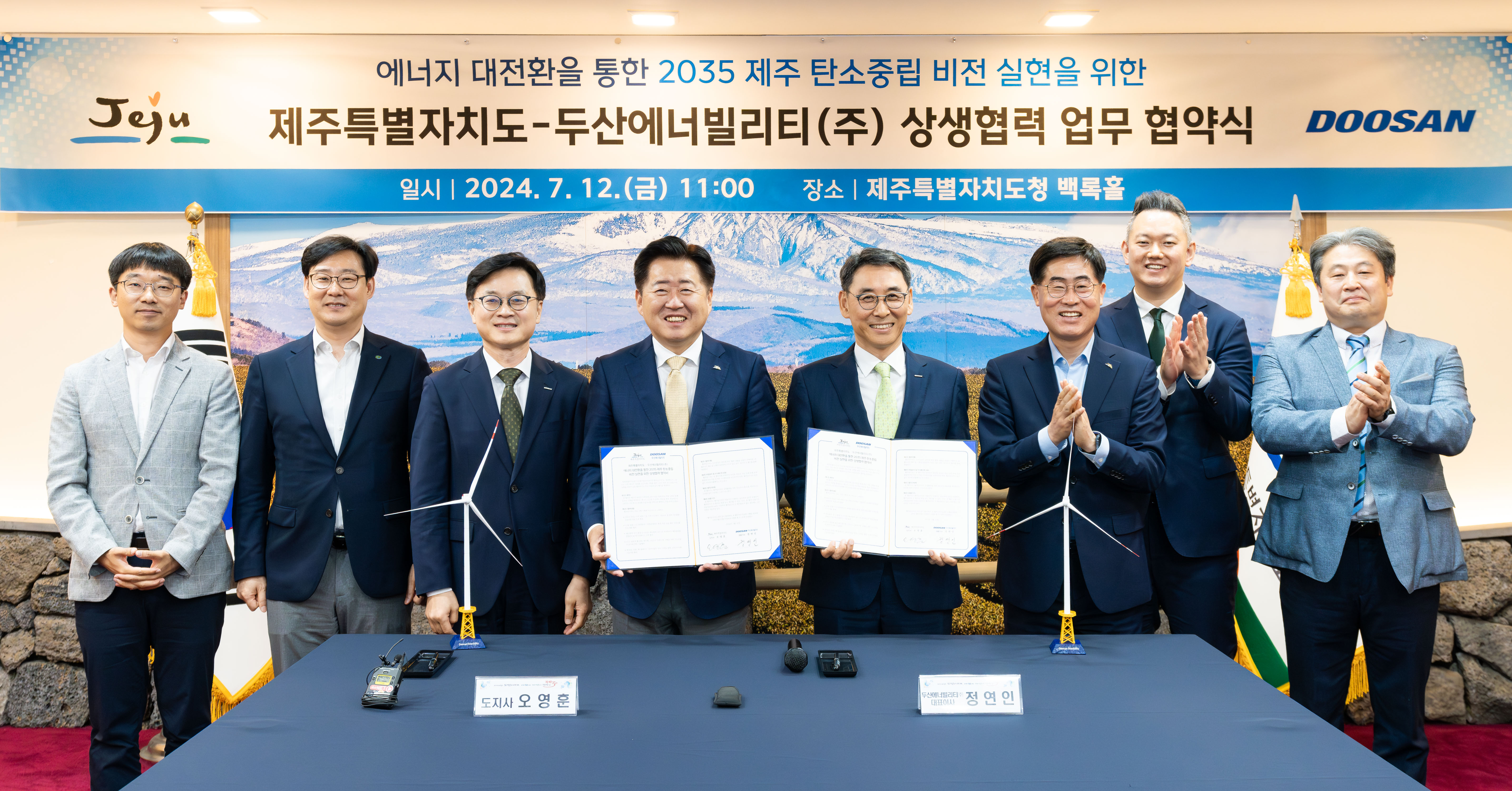 On July 12, Jeju Governor Young-hun Oh (4th from the left) and Doosan Enerbility Vice Chairman Yeonin Jung (5th from the left) pose for a group photo after signing the “MOU on Cooperation for Achieving Carbon Neutrality by 2035 Via Energy Transition” at the Jeju City Hall’s Baekrok Hall.