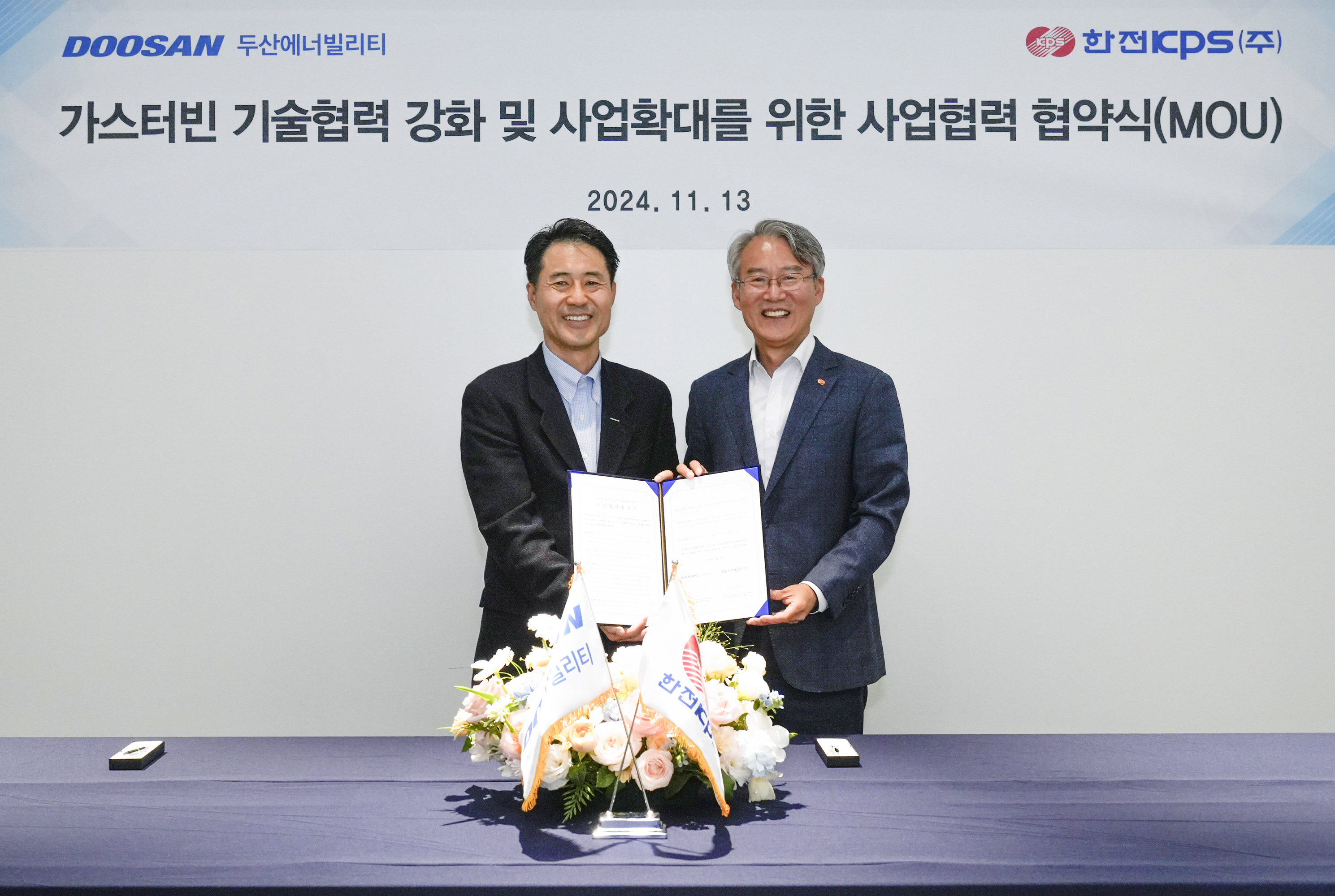 Doyoon Kim, Director of KEPCO KPS’ Power Generation & Safety Division (on the right), and Seungwoo Sohn, CEO of Doosan Enerbility’s Power Services BG, pose for a photo together at the MOU signing ceremony held at the Bundang Doosan Tower on Nov 13.