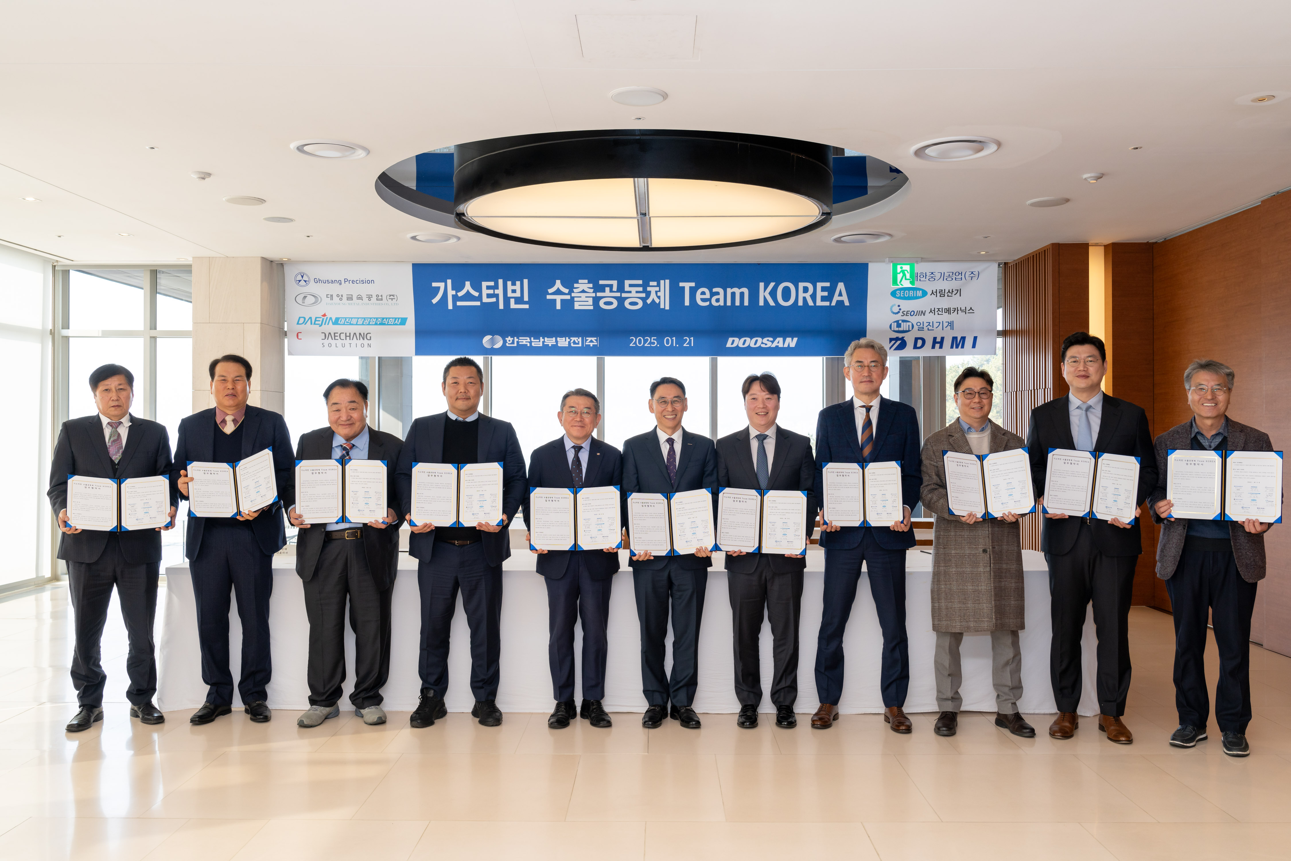 Jundong Kim, KOSPO CEO  (5th from the left) and Yeonin Jung, Doosan Enerbility Vice Chairman & COO (6th from the left) pose for a group photo with the representatives of local partners at the “Team Korea Consortium for Gas Turbine Exports” MOU signing ceremony held at Doosan Enerbility’s Changwon headquarters on Jan 21.