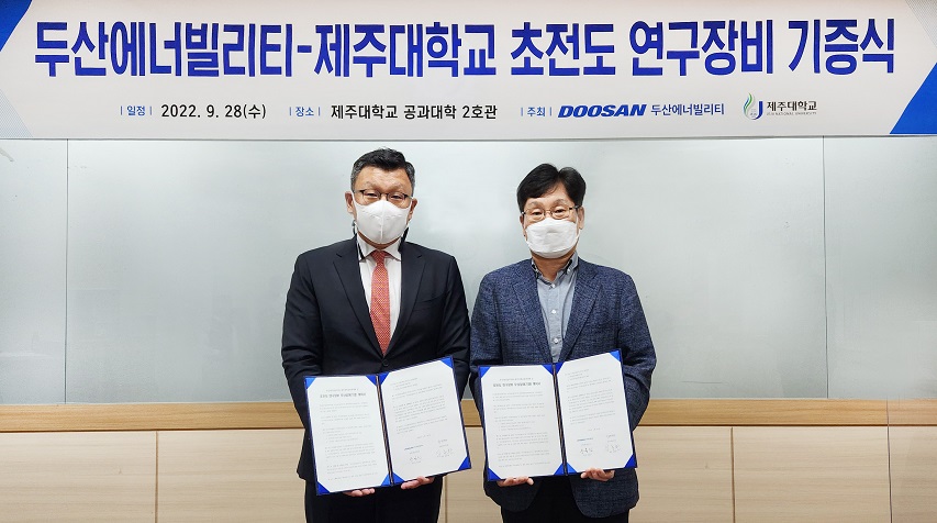 28일 제주대학교에서 열린 ‘두산에너빌리티-제주대학교 초전도 연구장비 기증식’에 참석한 제주대 공과대학 학장인 임종환 교수와 두산에너빌리티 전략혁신부문 송용진 부사장(왼쪽)이 서명 후 기념촬영을 하고 있다.