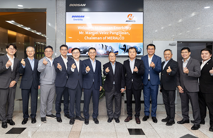두산에너빌리티 창원 본사를 방문한 필리핀 최대 전력기업 메랄코(Meralco)의 마누엘 베레즈 판길리난 회장(우측 6번째)과 두산에너빌리티 정연인 부회장(좌측 6번째), 김정관 마케팅부문장(좌측 5번째) 등 관계자들이 기념촬영을 하고 있다. 