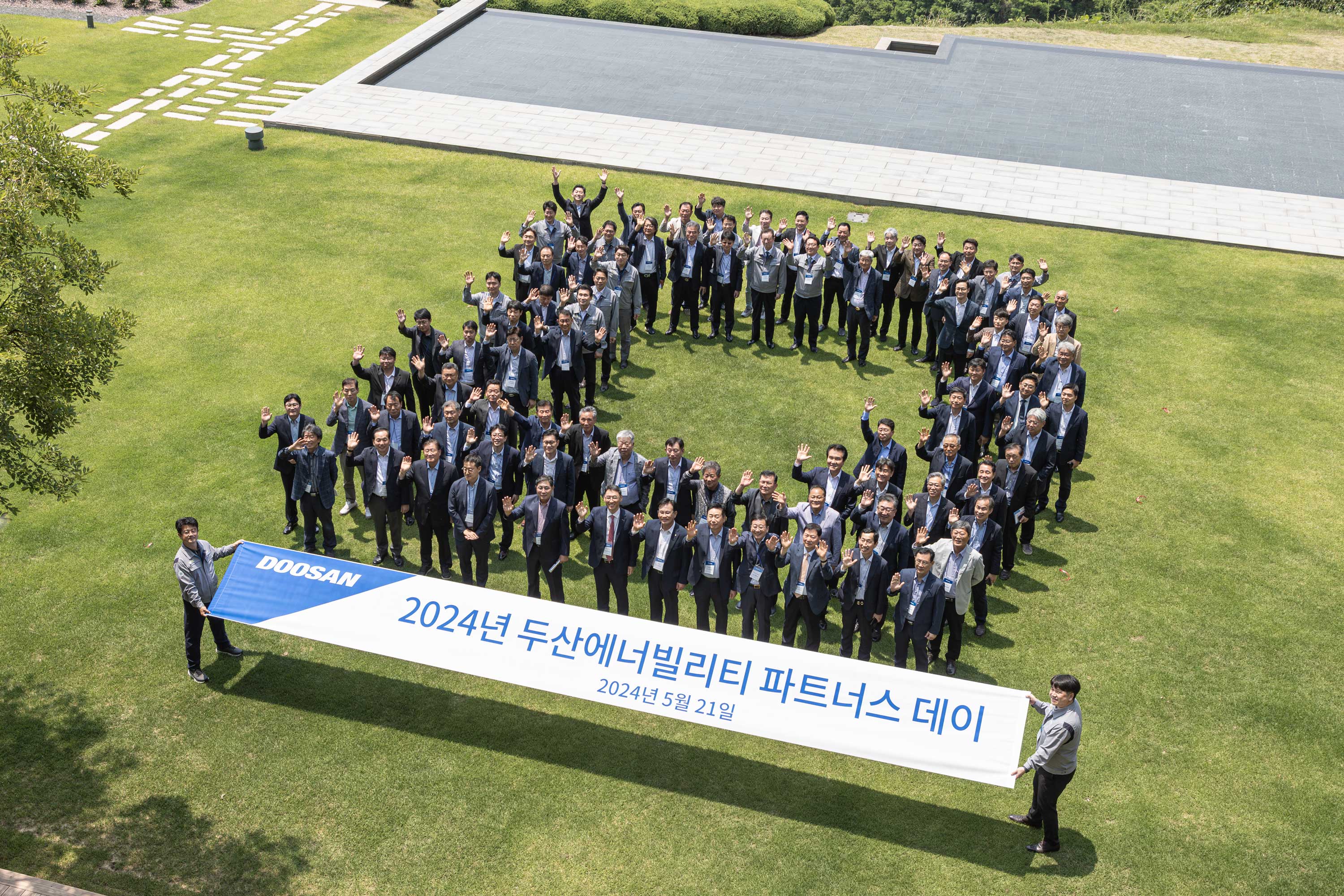 ▲ 지난 5월 두산에너빌리티 창원본사에서 열린 '2024년 두산에너빌리티 파트너스 데이' 행사에서 참석자들이 단체 기념사진을 촬영하고 있다.